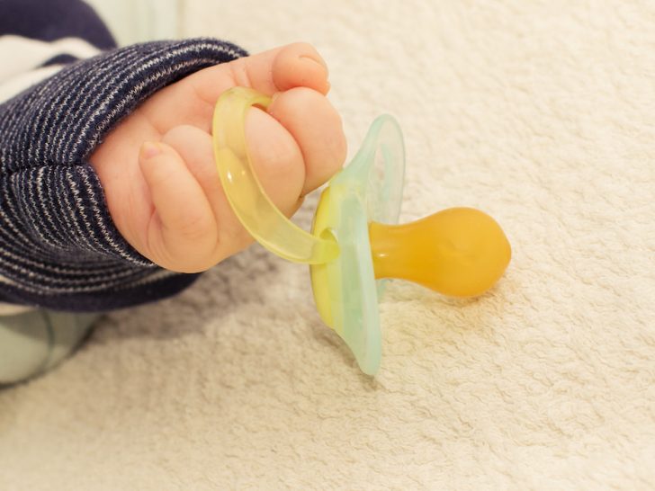 Close up of baby little hand with pacifier dummy