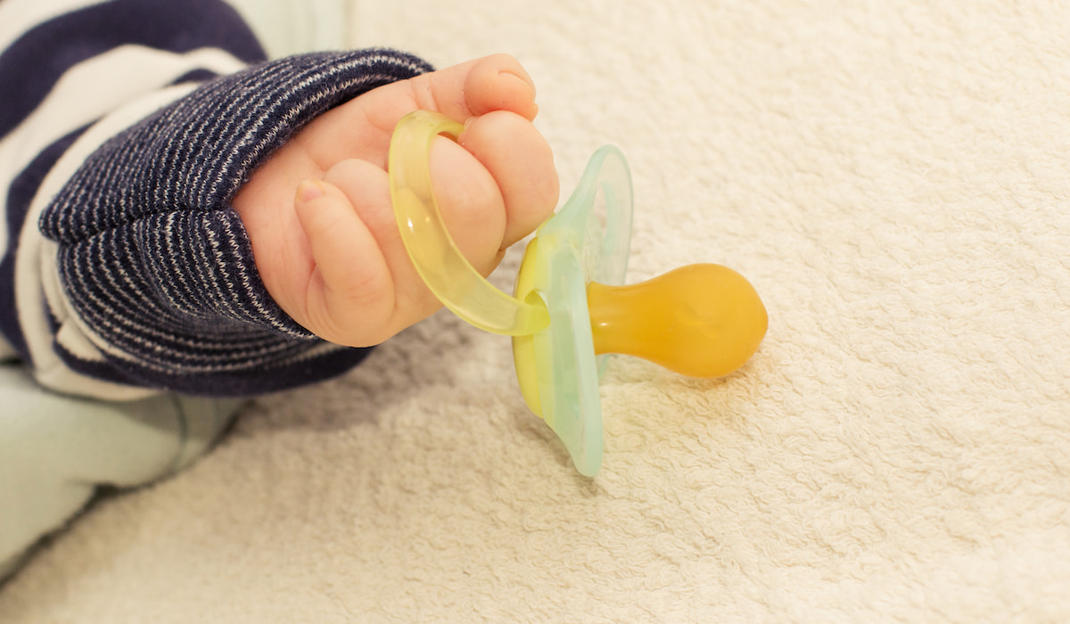 Close up of baby little hand with pacifier dummy