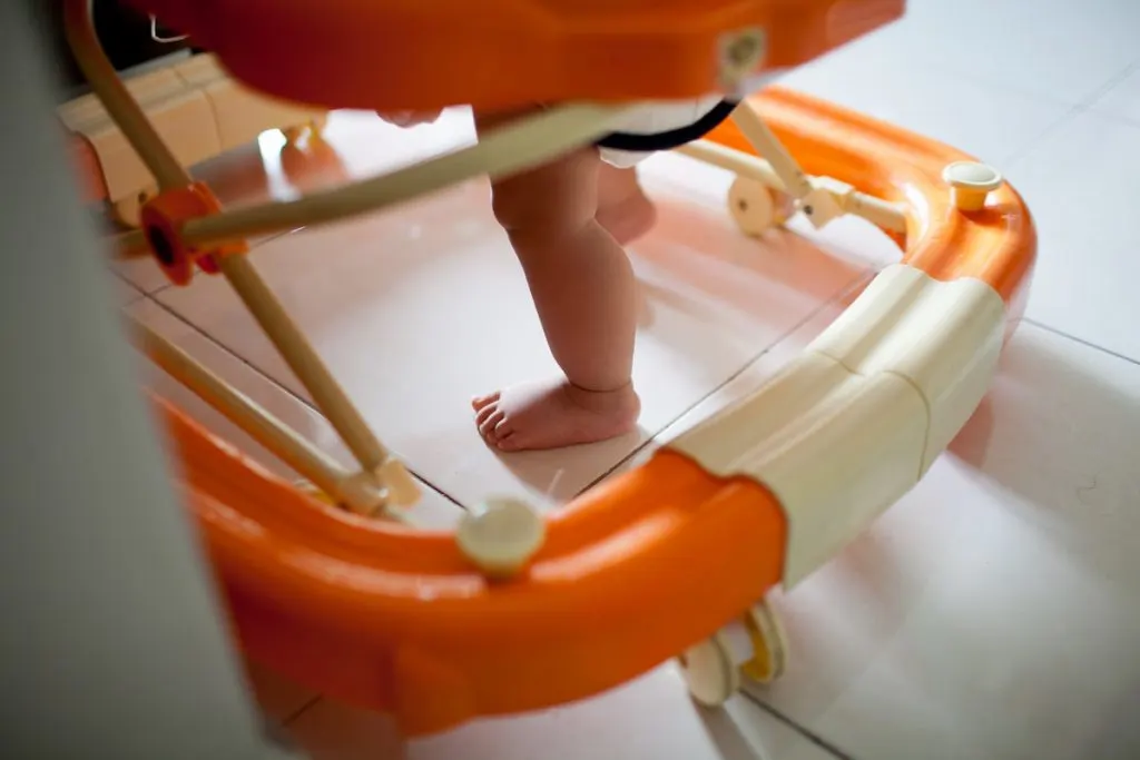Baby boy practicing walking using baby walker