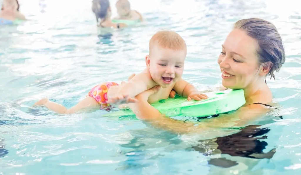 Baby girl wearing swimming diaper with her mother