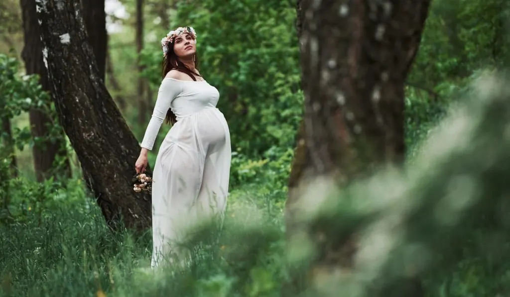 Beautiful pregnant woman in dress have a walk outdoors photoshoot