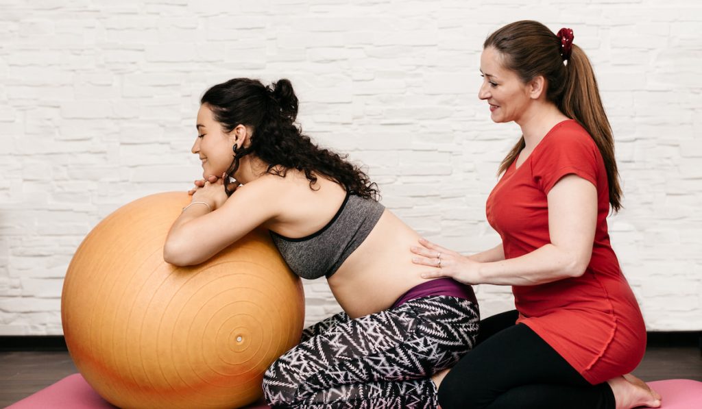 Doula Relieving back pain for pregnant woman 
