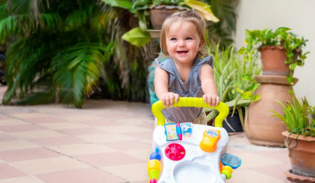 Happy baby with walkers on the garden