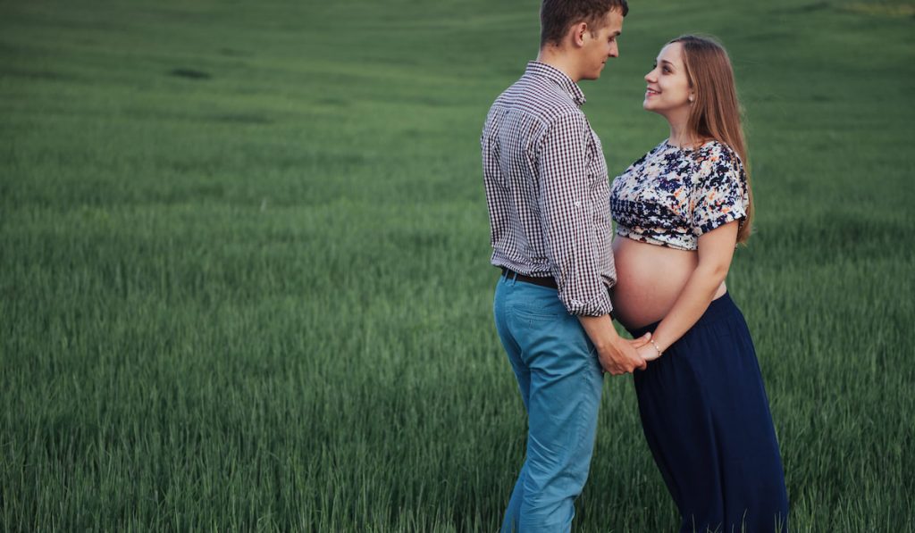 Happy couple awaiting baby. Beautiful and young parents photoshoot