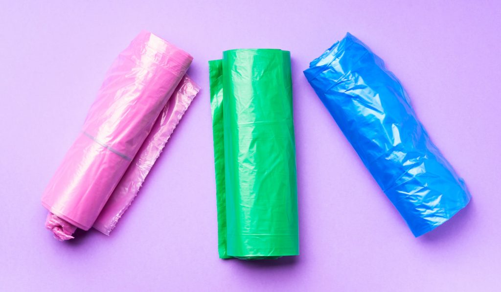 Plastic bags colorful rolls on purple background
