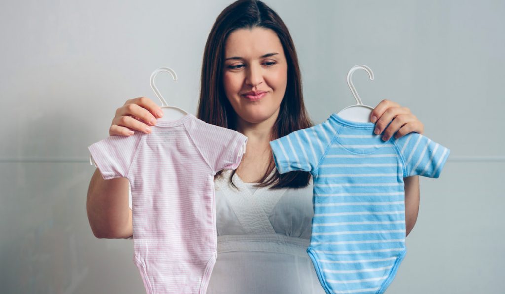 Pregnant choosing baby bodysuits
