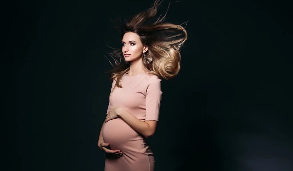 Windy effect on studio portrait of pregnant woman