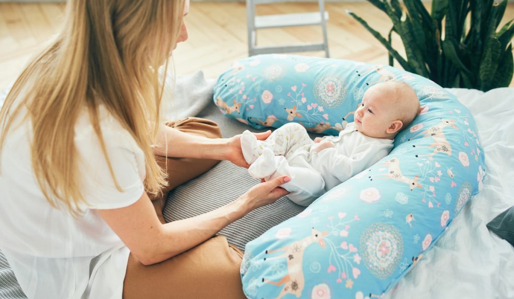 Woman and baby girl on the pillow at home 