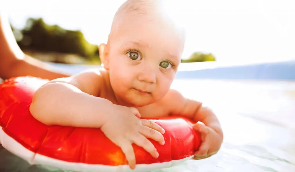 baby boy in his floatie on the beach 