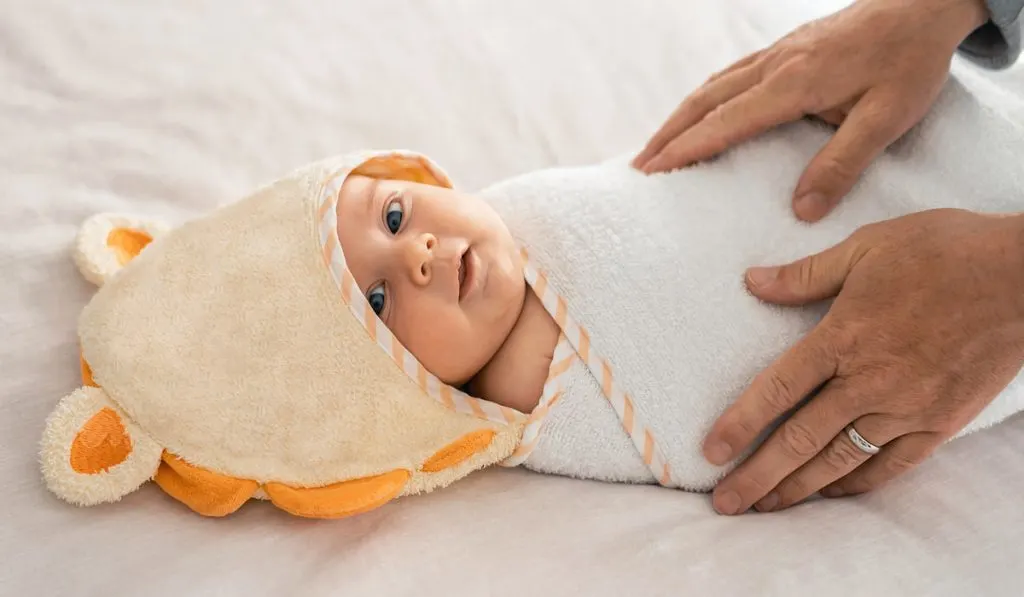 baby boy lying on the towel before bath