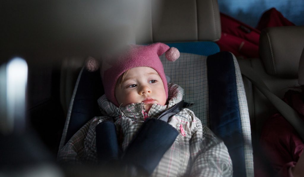  baby sleeping in a carseat with blanket