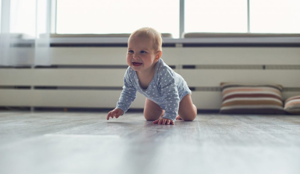 little baby boy crawling on floor at home
