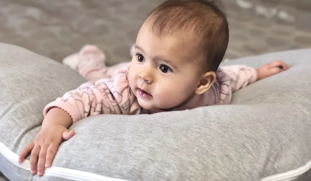 little baby girl tummy time on boppy pillow