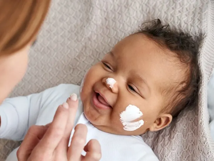 mother-applying-skin-care-cream-on-cute-funny-baby-face