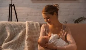 smiling-young-mother-breastfeeding-baby-at-night