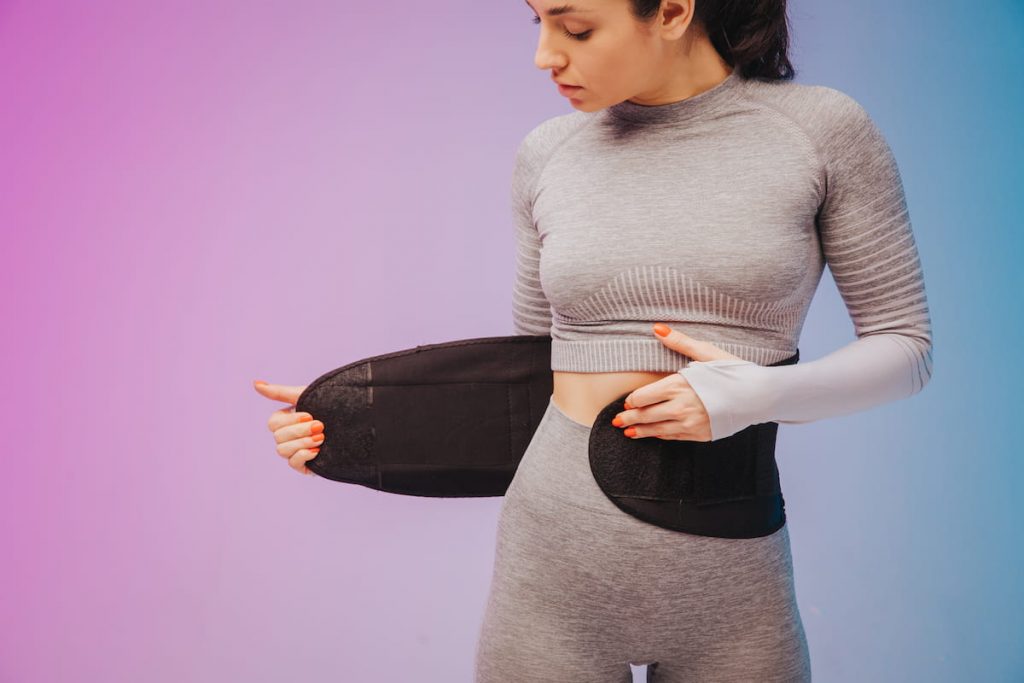 woman-training-fitness-waist-trainer-belt-back-isolated-on-gradient-studio-background-in-neon-light